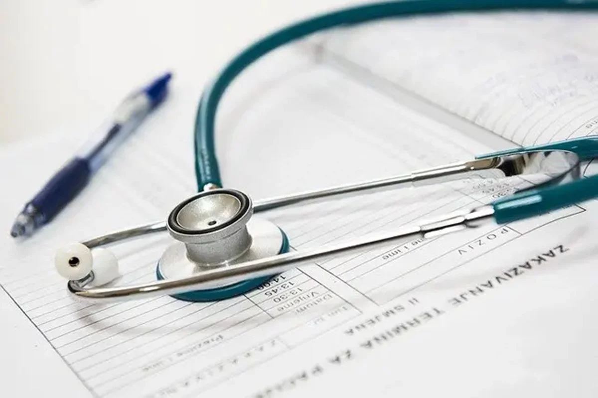 foto ilustrativa de um estetoscópio em cima de relatórios médicos